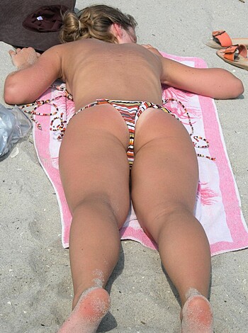 "A nude beach bitch sunbathing with her shitty-assed tits and ass crack hangin' out."