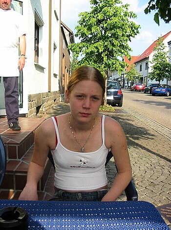 A shirtless bitch sits on a fucking blue table.