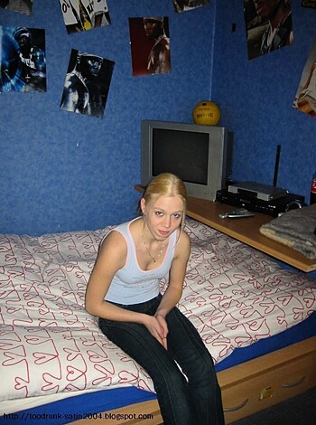 The woman is sitting on a fucking bed with her legs spread open, showing off her pussy while she rubs one out.