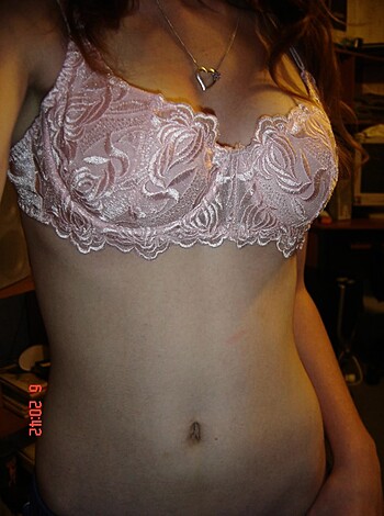 """
A frilly, fucking sexy pink bra worn by a hot chick with big tits.
""" 

or 

"""
A floral-patterned lingerie, made of silky fabric, rests on the shoulders of a busty blonde woman.
"""