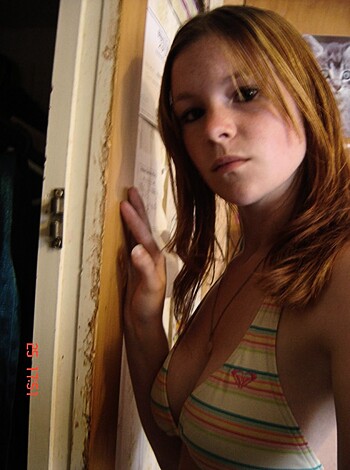 """
This photo depicts a hot chick in a bikini with her hand on a wall, leanin' and lookin' all sexy-like.
""
