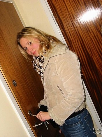 "A bitch is leaning against a door with her ass hanging out of her jeans while she's wearing a flannel shirt."