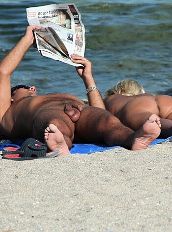Three dudes, nekkid as fuck, chillin' on a towel on the beach.