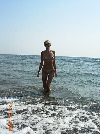 A busty blonde chick is pissing in the sea while wearing a skimpy yellow bikini. She's got her arms spread wide and her head thrown back, enjoying the feeling of urine hitting the salty waves.