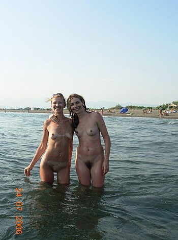 "Two nude bitches grinnin' at each other while wet in the sea."