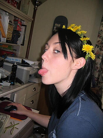 Vulgar description: "Hot bitch with her middle finger raised flipping off the camera while donning a bright-ass yellow daisy crown."