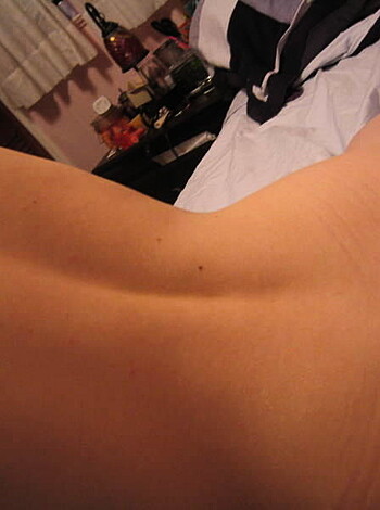 A bare-assed chick sleeping on her back in bed.
