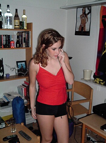 A barefoot bimbo with big tits, tight tank and tiny shorts clutching a cellie on the horn, chatting away like some kinda street-walking slut.