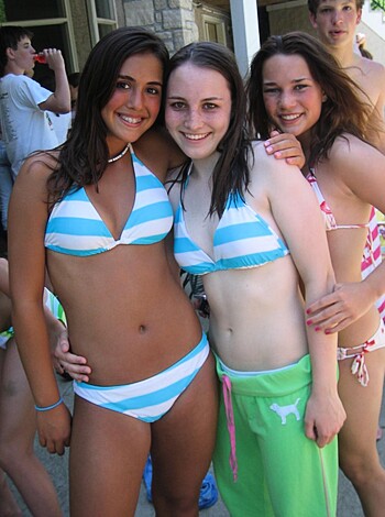 Two hot babes wearing bikinis, making out and looking happy.