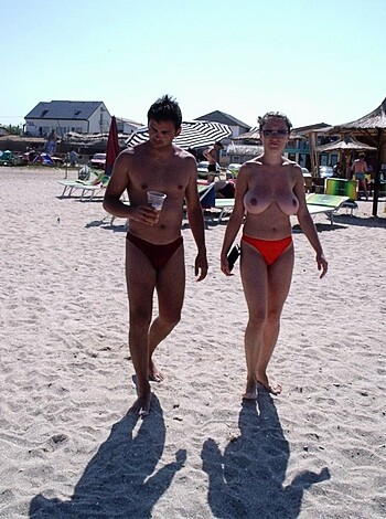 A couple of fucking nude dudes strolling down the sandy shore with their balls hanging out and cocks swinging.