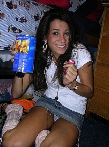 "A hot babe with big tits sits on her bed and chugs back a couple of ice-cold cans of Budweiser."