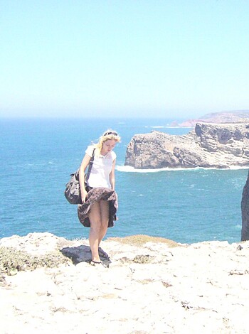 Here's the fuckin' image of a hot bitch posin' like a model, her naked legs dangling over the fuckin' cliff edge, lookin' all sexy and shit.