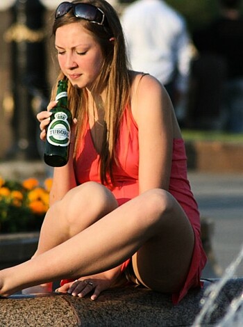 "Fucking hot chick loungin' on a bench, kickin' back a brewsky while she shows off those smoking hot gams in her sexy red dress."
