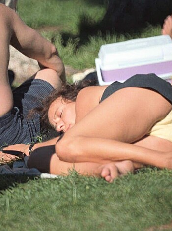 Here's the vulgar description of the image:
This bitch is sleepin' in the fuckin' park, showin' off her shitty ass shorts.