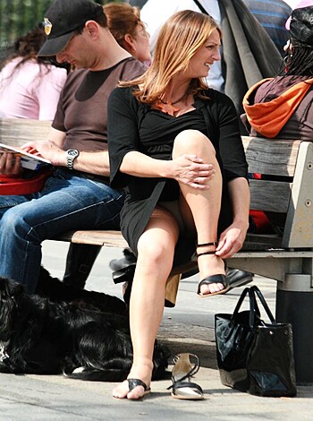 The bitch is sitting on a bench with her tits spilling out of her tight-ass dress, rocking those stilettos like she's trying to fuck shit up.