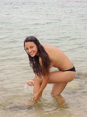 A naked chick scrubbing her pussy with seawater while sunbathing on the beach.