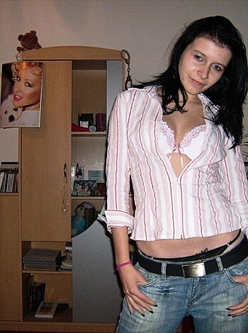 A chick with her tits hanging out of a pink button-up shirt and some tight jeans.