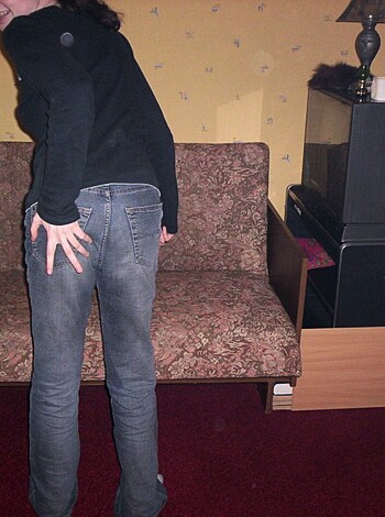 A hot piece of ass writhes on her back on a couch while her legs are spread wide open, revealing a glimpse of her pink pussy.