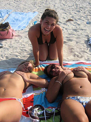 "Two hot bitches fuckin' loungin' on the beach in their titties, while one cracks up and another pair of ass cheeks show up."