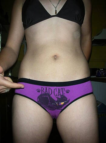 Here's the description: "Bitch in a purple thong with 'Bad Cat' printed across her ass cheeks."