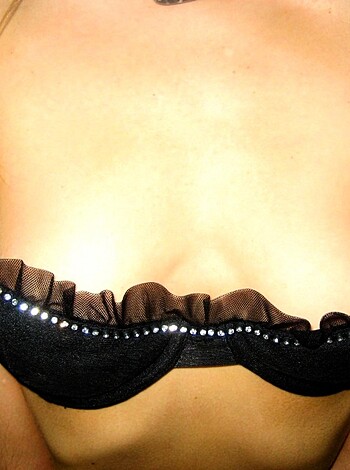 A slutty bitch is showing off her fucking tits in some black bra shit.