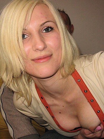 A busty bitch with hard titties poking out of her top, wearing a bra that can barely contain them.