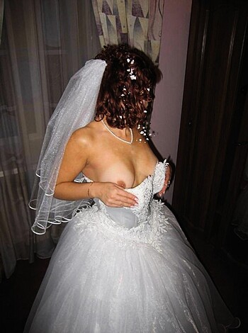A busty broad bares her boobs in a white lacy bra and panties.
