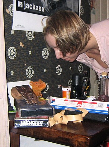 A naked chick bending over a dildo-filled table.