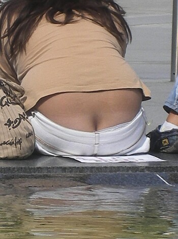 "Boldly exposing her asscheeks through the rip in her denim."
