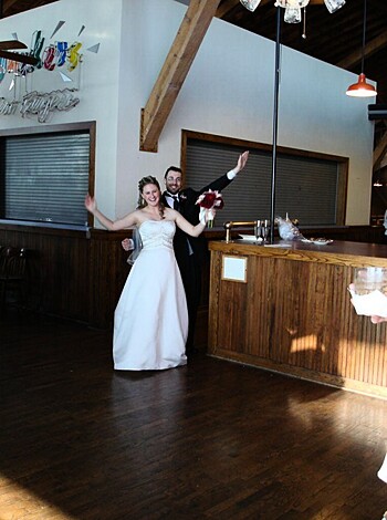 The bride is seen wearing a white dress while she sways her hips to the music as she dances with her new husband. The groom, dressed in a tuxedo, also joins in on the fun and can be seen smiling as he holds his beautiful wife close.