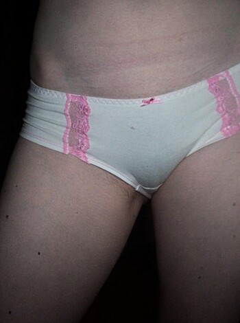 A close-up shot of a chick's toned thigh, with the outline of her sexy panties peeking out from under her dress.