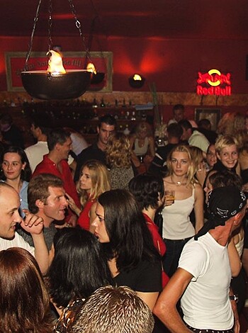 "Check out this fucking image of assholes getting drunk and shaking their asses like dumb motherfuckers at some fucking bar or club. Look at those idiots talking and dancing and acting like they're having a goddamn good time, what the hell."