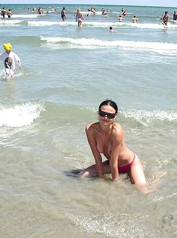 A chick in a teeny bikini, sittin' on the shore with waves crashin' all around 'er, lookin' all hot n' shit.