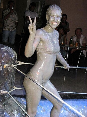 "Here's a photo of some slutty bitch covered in mud with body paint, showing her tits and pussy while flipping the bird for no reason."