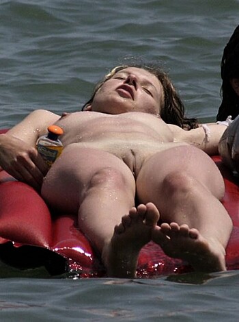 "Check out this photo of two chicks loungin' on an inflatable raft while one fucks around in the buff and the other bitch is rockin' a skimpy bikini. Shit's lit."