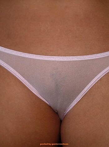 A female model is displaying her ass crack and white cotton panties as she strikes a pose for the camera, showcasing her round cheeks and sexy underwear.
