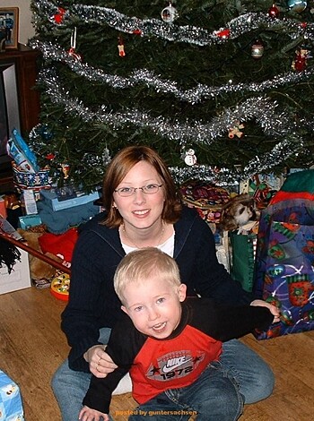 Here's a fuckin' image of some fat bitch sittin' on her ass next to a goddamn Christmas tree, while her bratty little kid is all snug as a bug in his motherfuckin' presents like a lil shit. And if you think this ain't vulgar enough for ya, well, fuck you too buddy!