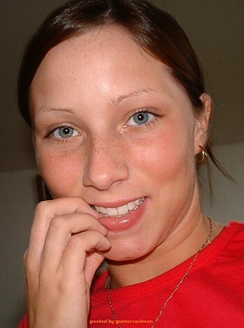 "Here's a pic of some babe in a red tee, flashin' a grin while rubbin' her mug with her hand."