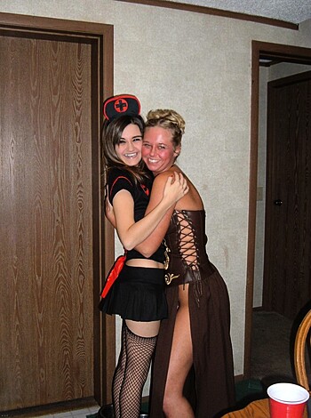 A smoking hot blonde in a skimpy gold bikini makes out with her sexy younger girlfriend in a slinky schoolgirl outfit, complete with black stockings and leather boots.