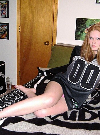 A horny chick in a football jersey fucking on her bunk bed.