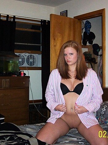 This image depicts an overweight female with long, stringy blonde hair wearing a shitty-ass pink fucking bathrobe and some frilly lace panties that probably cost more than my rent. She's sitting on the toilet, presumably taking a dump, and her face looks like she's either about to shit herself or start crying over how pathetic her life is. Fucking gross.