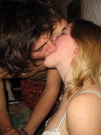 This fuckin' picture displays a dude smoochin' on some chick in the bedroom, with the both of 'em lookin' like they're havin' fun as hell.