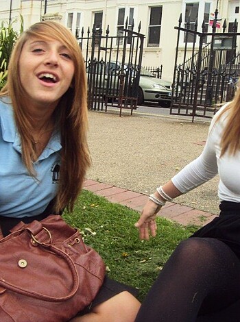 Two hoes cracking up at each other while lickin their chops and strokin their necks.
