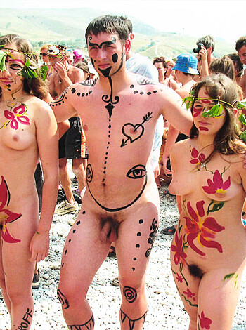 Three naked fuckers covered in flower paint doing some beach body art shit.