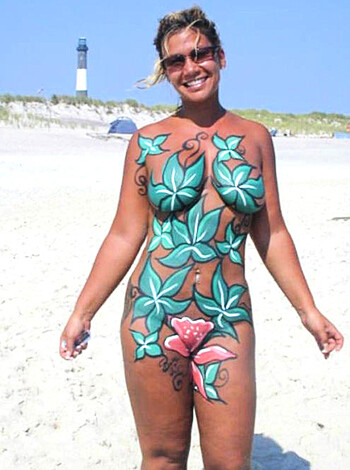 """
A bikini-clad chick with tits and ass splayed out on the sand, her skin covered in a sexy ass pattern that looks like dicks and pussy.
"""