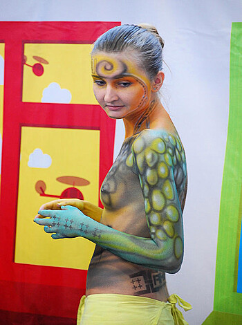A naked chick covered in paint and wearing a shit load of body jewelry.