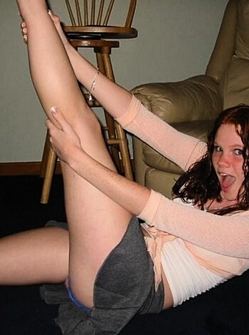 A chick with a tight mini skirt spreads her legs wide, flashing her navel while she stretches up tall.