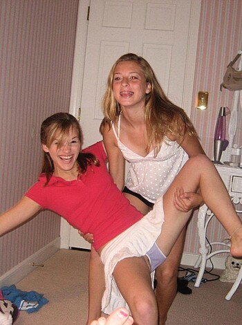 A vulgar description of this image would be: "Two hot bitches grinding on each other in a fucking smoky ass room."
