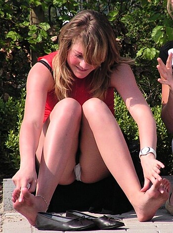 This bitch got her ass on some fucking bricks with her tits out for all to see while she sits cross-legged like a goddamn chimpanzee, shit. Her ugly white legs are crossed and she's lookin' down at those hooves that don't even have the decency to be covered up by some goddamn shoes, fuckface.