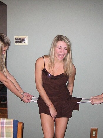 Three chicks stripping bitch who's dressed up in a shitty brown frock, while two others lend a hand.